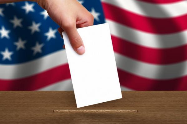 Hand placing ballot in box